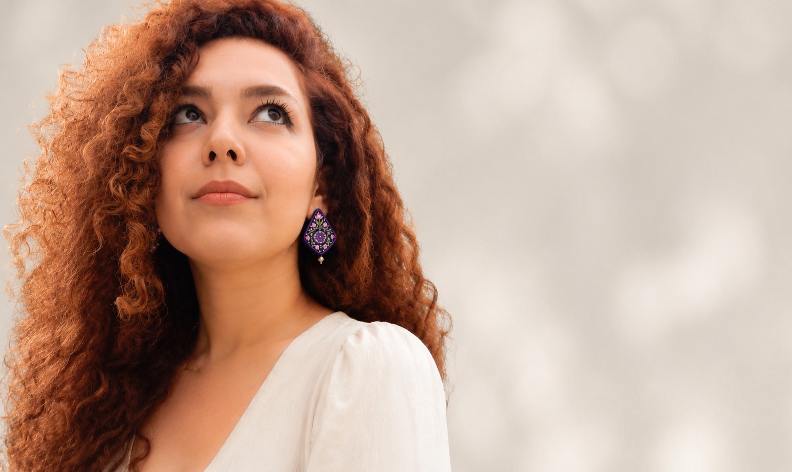Bahar, créatrice de Bahazar, portant des boucles d'oreilles brodées de la collection Yalda