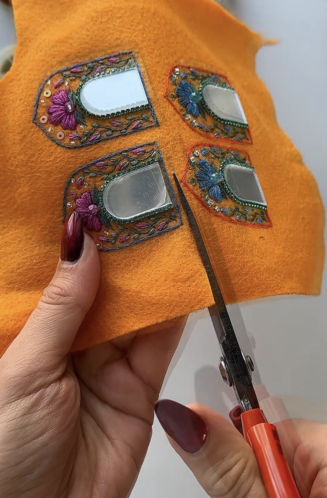 Découpe à la main de broderies sur feutre orange